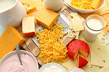 an array of dairy products, including several types of cheese, yogurt, and milk