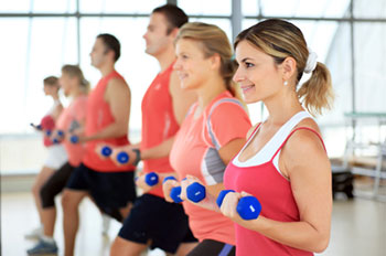 men and women participating in an exercise class using hand-held weights