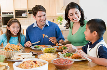 two adults and two children eating a meal together