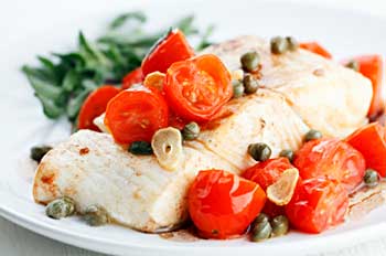 Healthy meal of halibut with tomato, caper, and garlic sauce