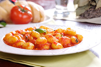 a plate of gnocchi with tomato sauce