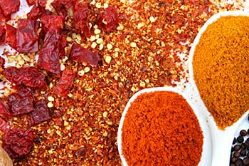 a variety of spices spilled on a flat surface in a decorative manner