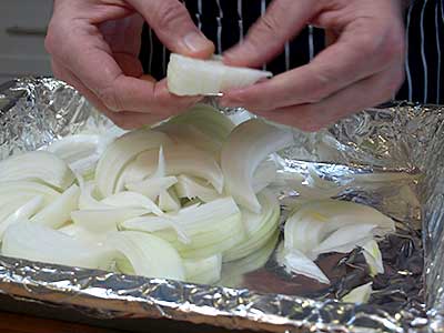 Scatter the onions in the bottom of a small roasting pan...