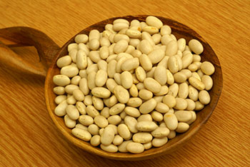 dry white beans in a wooden bowl