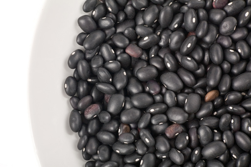 a white bowl containing dried black beans
