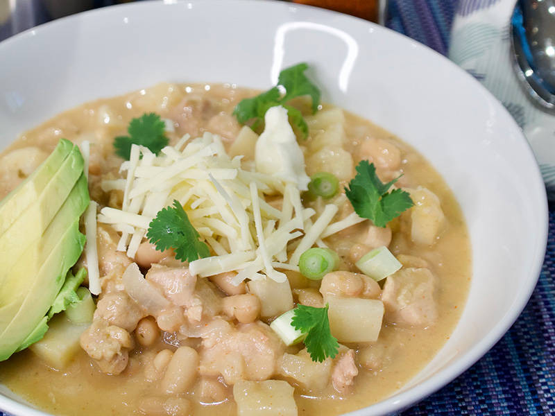a bowl of white chili garnished with sour cream