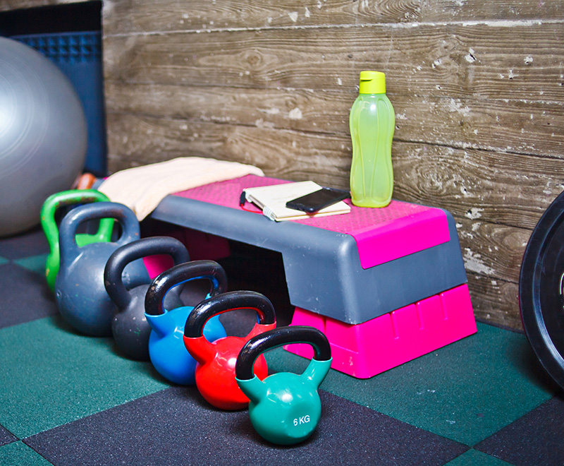 Colorful kettlebells set and other functional exercise equipment on the gym floor