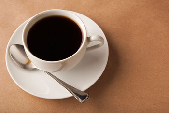 a cup of black coffee presented on a saucer