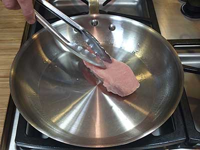 Heat the pan and spray with oil, then add the pork chops.