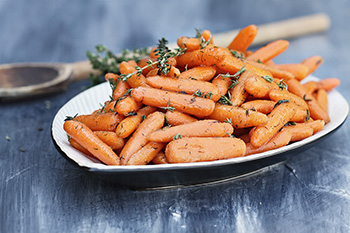 a bowl of baby carrots cooked with thyme