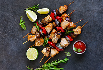 three chicken kebabs with chunks of chicken, mushrooms, and red onions